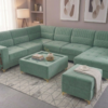 Luxurious L-shaped emerald green velvet sectional sofa with gold legs and matching ottoman.